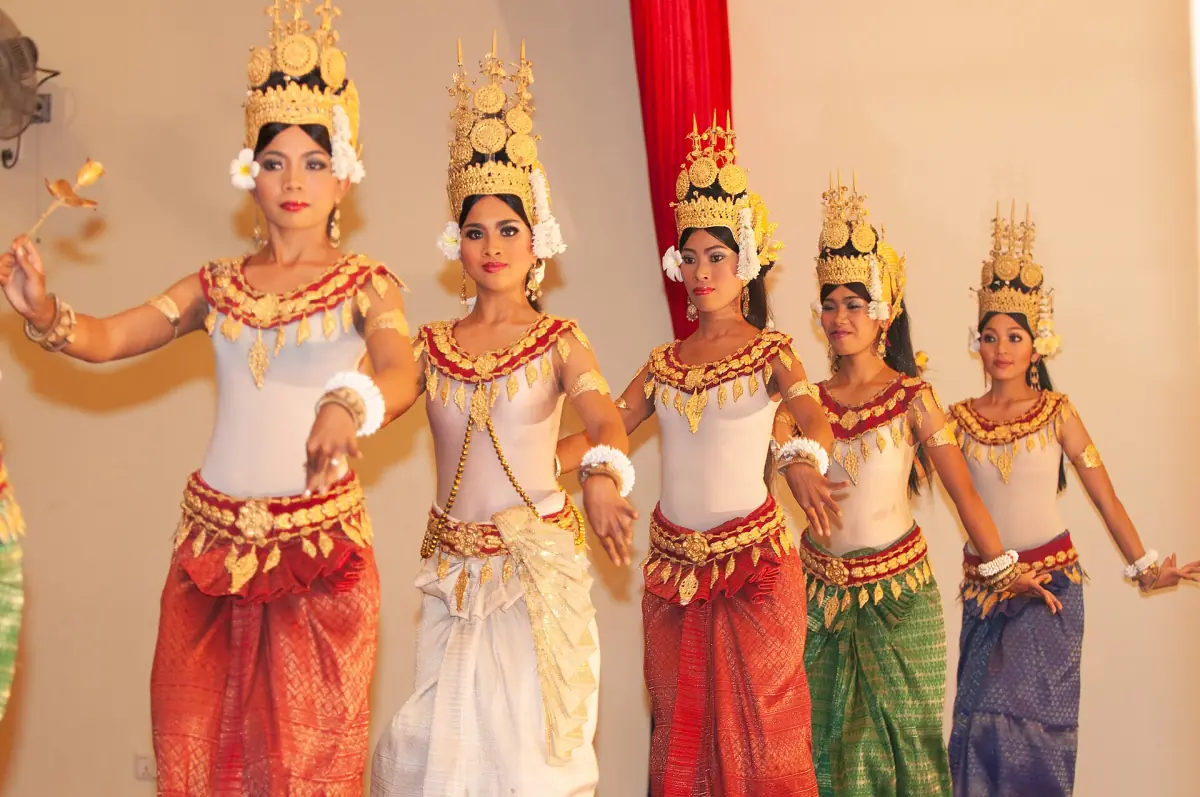 Apsara dancers in golden headdresses and colourful costumes on stage