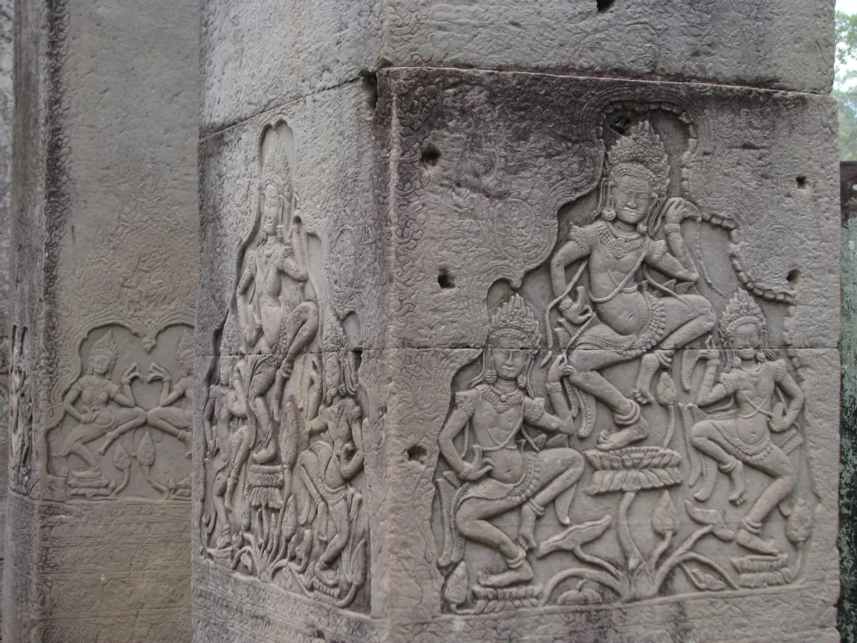 Carved apsara figures on the faces of a stone pillar at the Bayon