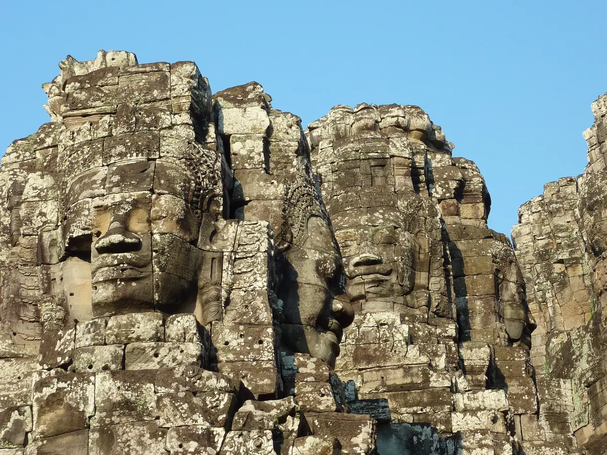 Several carved faces on the Bayon towers seen from below