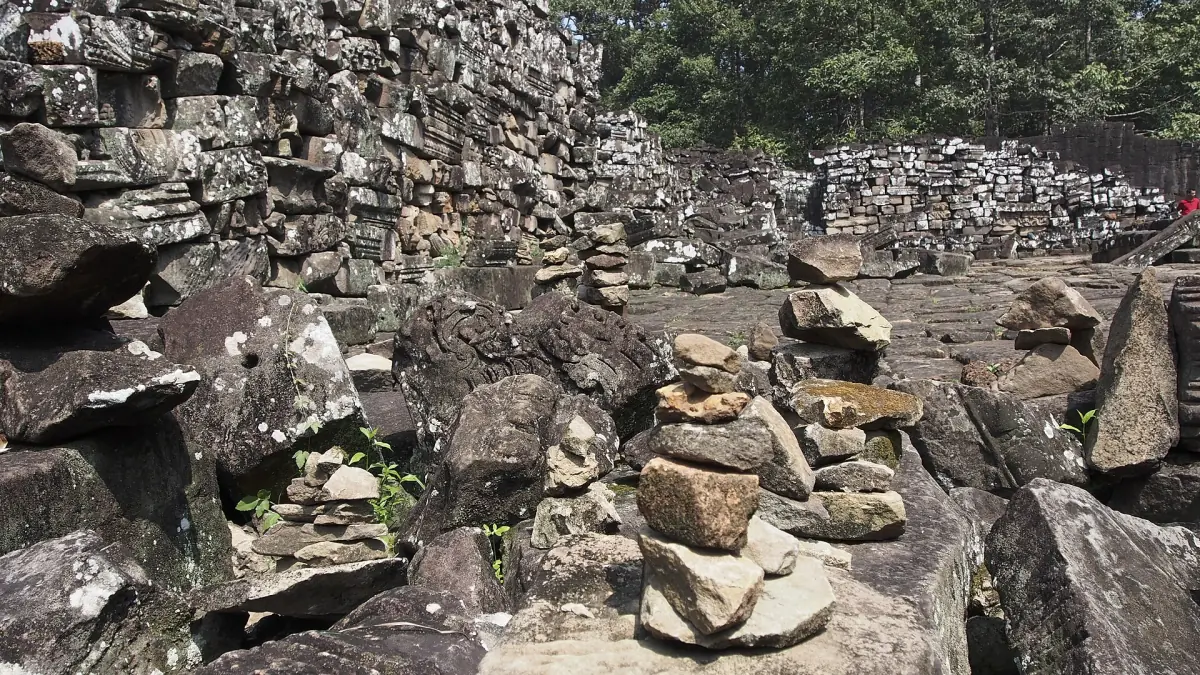 Heap of fallen stone blocks lying among the ruins at the Bayon