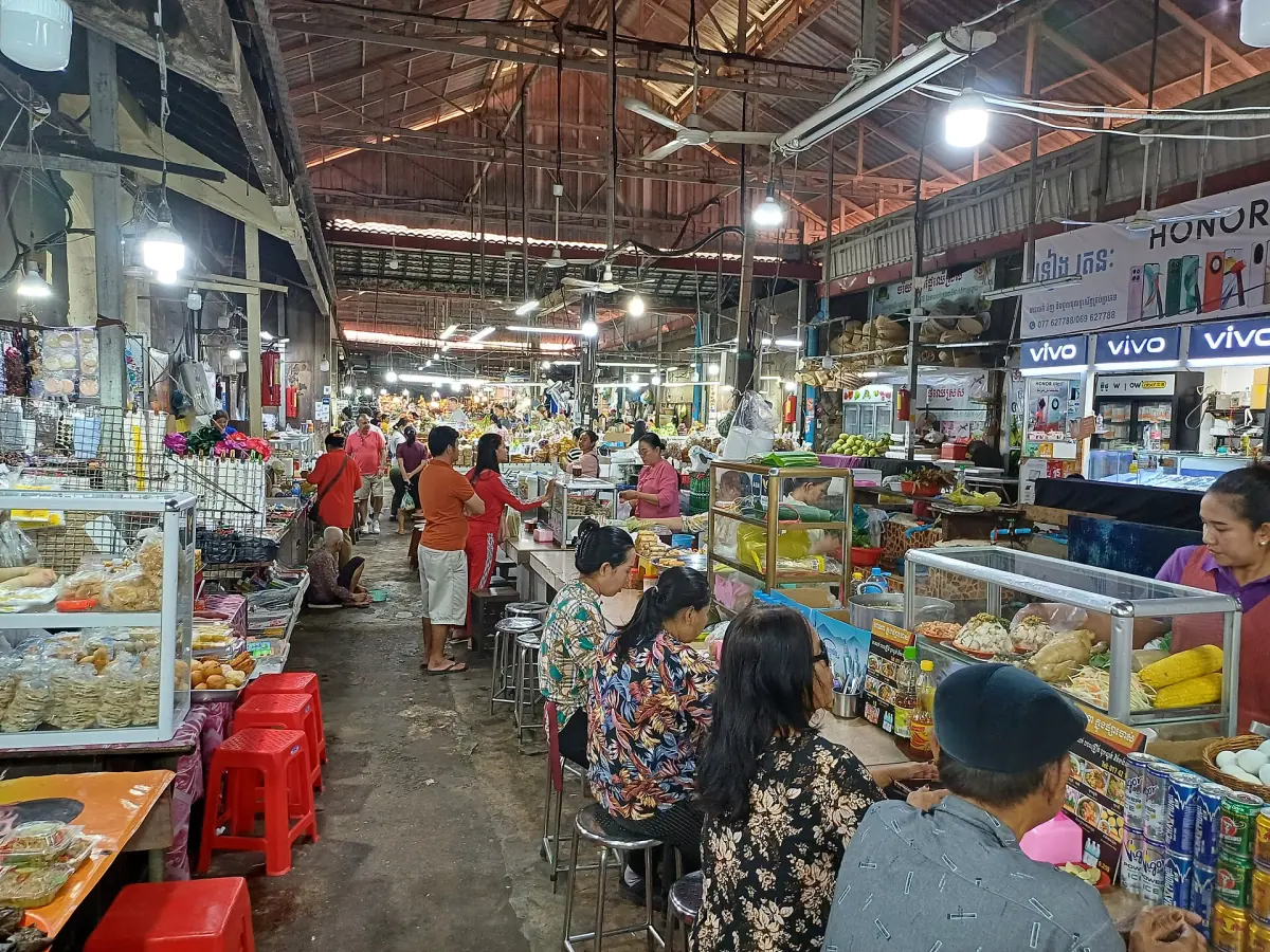 Covered market hall in Siem Reap with food stalls and shoppers